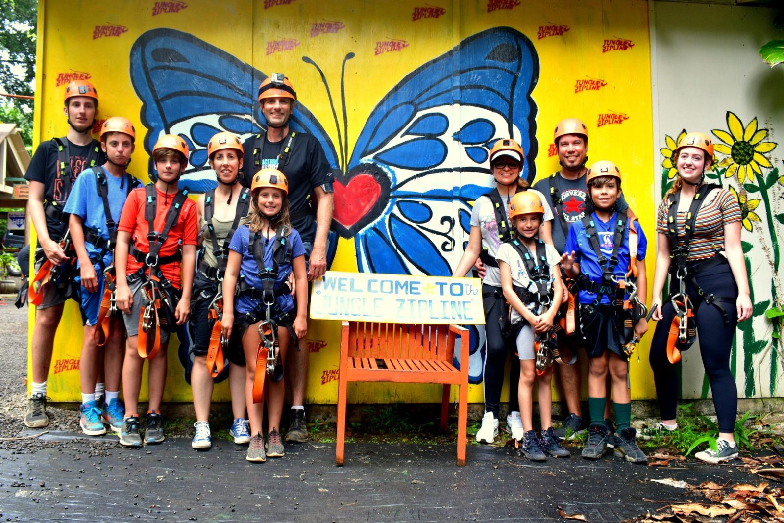Group of guests geared up in helmets and harnesses at check-in before the 8-Line Zipline Eco Tour, Maui